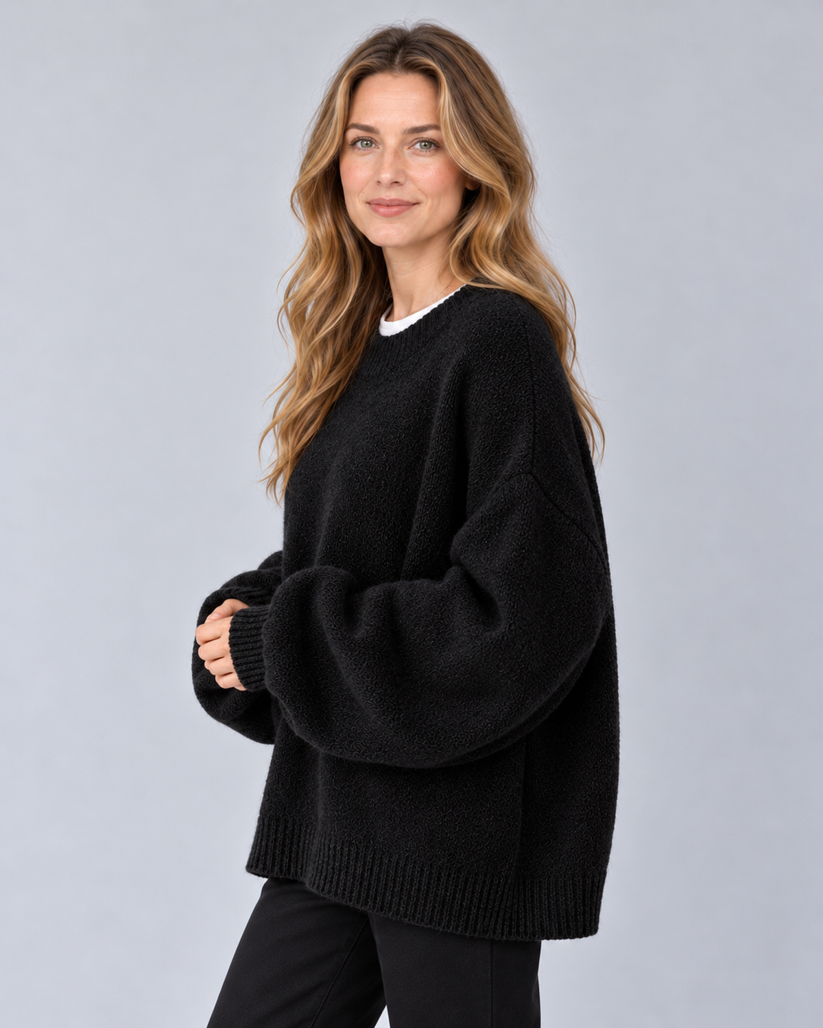 Women's round neck drop shoulder split hem jumper, black side, studio model photograph